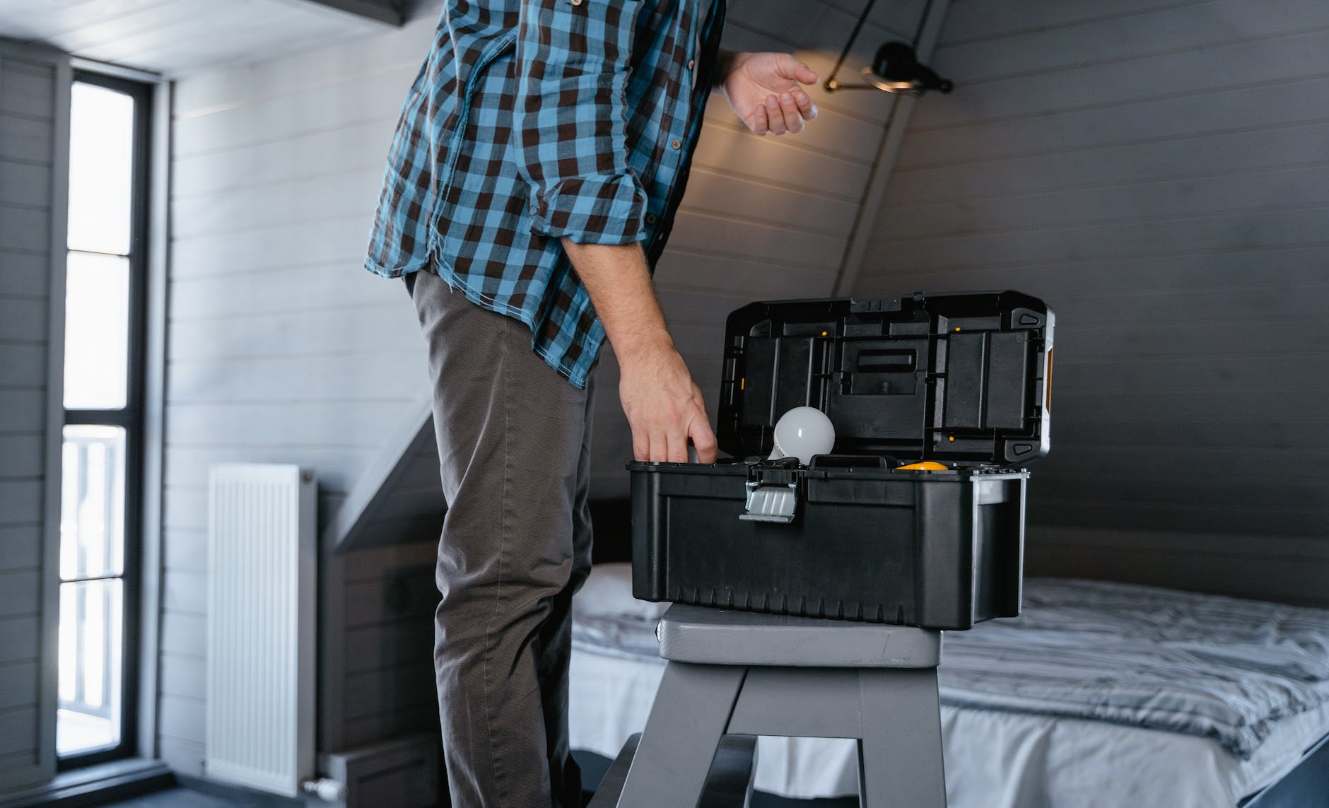 a person in plaid long sleeves standing near the toolbox