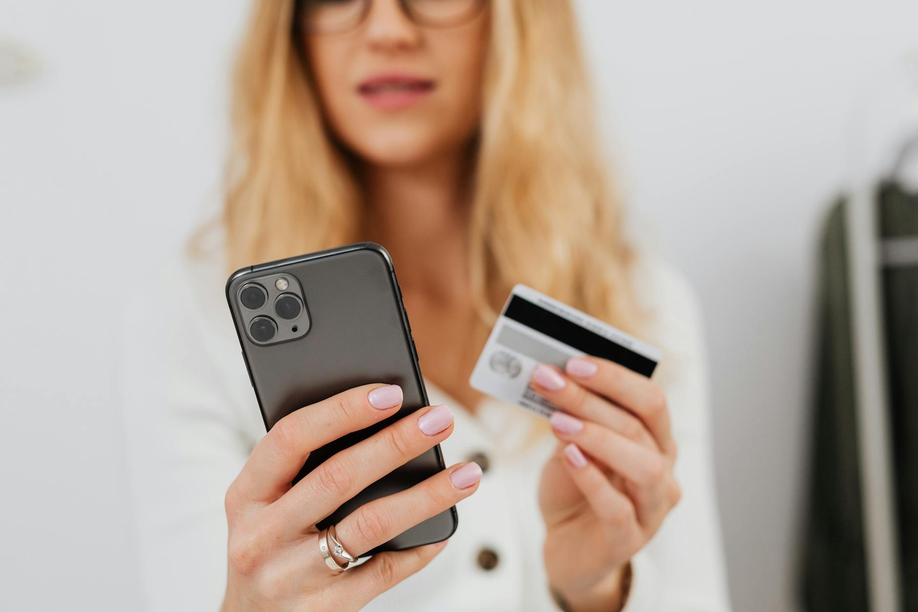 close up shot of a woman holding a credit card and smartphone